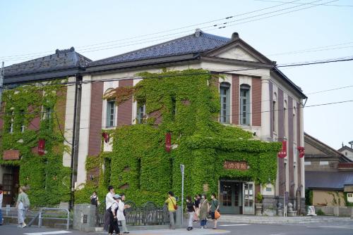 a building covered in green ivy on a street at 桔恭(KIKYO) in Otaru