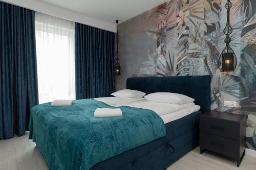 een slaapkamer met een groot bed en een blauwe deken bij Mielno Sea & Lake Apartment by Renters in Mielno