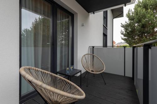 een balkon met 2 stoelen en een tafel bij Mielno Sea & Lake Apartment by Renters in Mielno