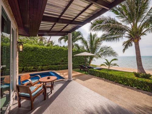 a patio with a table and chairs and the ocean at Sea Valley Resort in Lipa Noi
