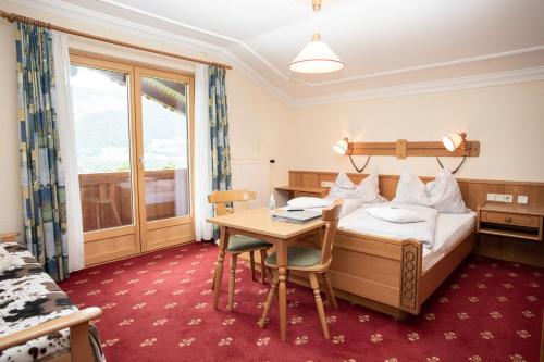 a hotel room with a bed and a table at Rosspointnerhof in Haus im Ennstal