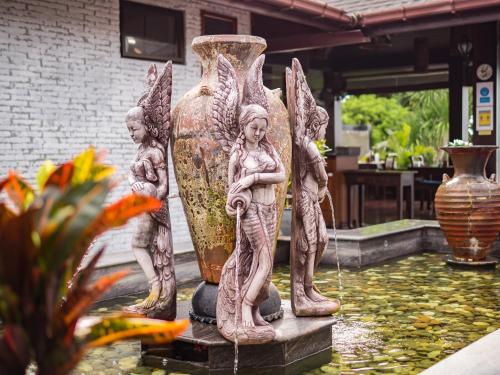 a statue of angels and a vase in a pond at Sea Valley Resort in Lipa Noi