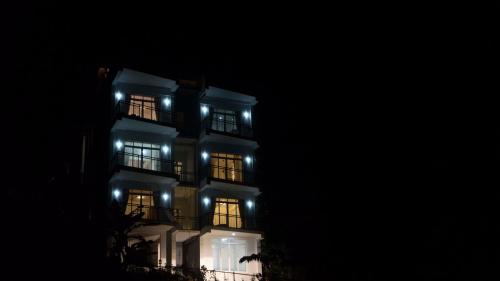 a lit up building with lit up windows at night at Amandara Hills Kandy in Kandy
