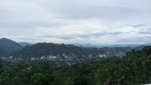 a view of a city with mountains and trees at Amandara Hills Kandy in Kandy