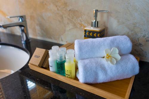 a bathroom sink with a towel and bottles of soap at Amandara Hills Kandy in Kandy