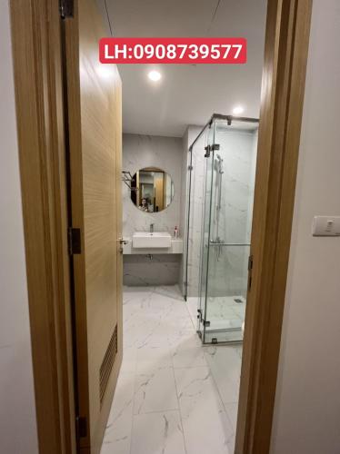 Un baño con ducha de cristal y lavabo. en Căn Hộ TMS 28 Nguyễn Huệ - Xuan Phuong House, en Quy Nhon