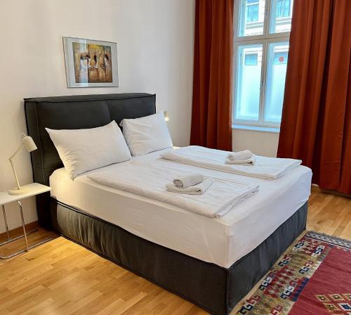 a bedroom with a large bed with two towels on it at Casa Nostra - Zentrale Wohnung am Augarten in Vienna