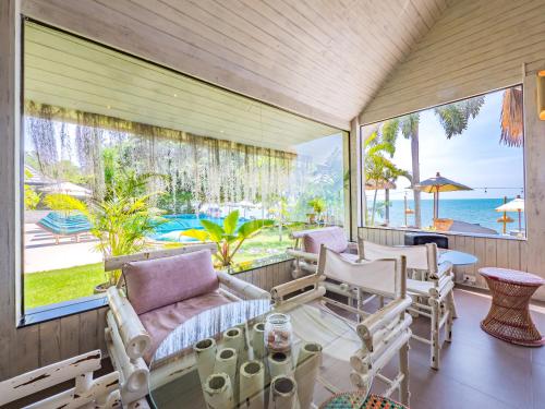 a screened in porch with chairs and a table at Sea Valley Resort in Lipa Noi