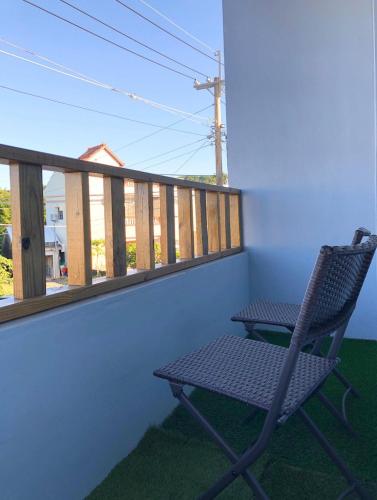 a chair sitting on a balcony with a window at Whose Home Inn in Checheng