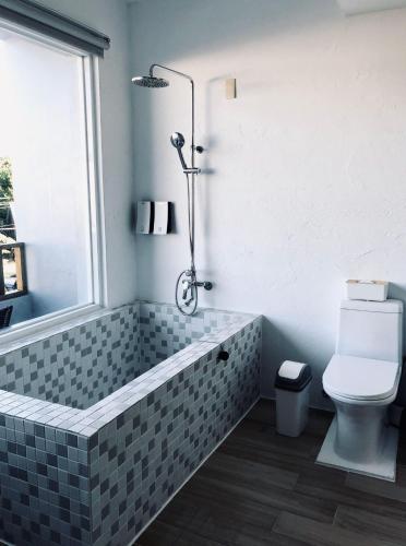 a bathroom with a bath tub and a toilet at Whose Home Inn in Checheng