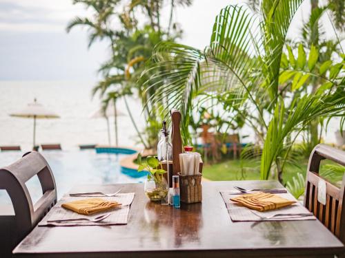 a wooden table with napkins and utensils on it at Sea Valley Resort in Lipa Noi