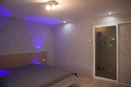 a bedroom with a bed with purple lights on it at LVC,LAC & NYC Apartshotel Faleza in Galaţi