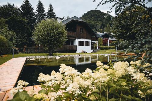 a house with a pond in front of it at Landhaus Alte Salzstraße - Your Austrian Home in Bad Aussee
