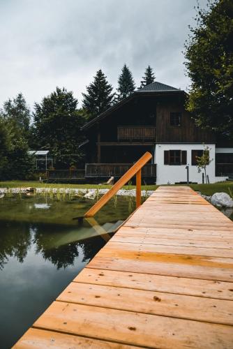 a wooden dock in front of a building on a lake at Landhaus Alte Salzstraße - Your Austrian Home in Bad Aussee