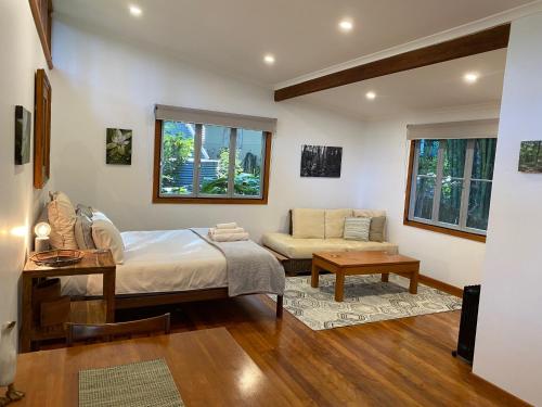 1 dormitorio con 1 cama y 1 sofá en Palmwoods Eco Escape en Palmwoods