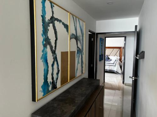 a hallway with paintings on the wall in a house at Luxury condo en Malecón, Alberca Infinity & Jacuzzi in Mazatlán