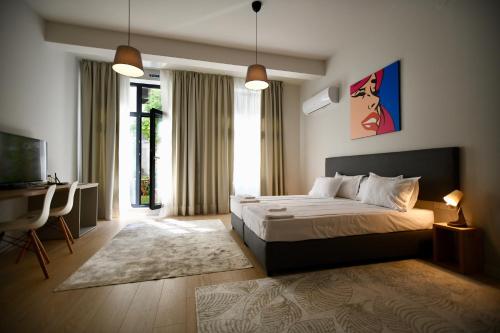 ソフィアにあるConnect Living Apartmentsのベッドと机とテレビのある寝室