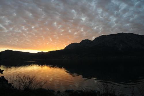 a sunset over a lake with mountains in the background at Ferienhof Margarethengut in Unterach am Attersee