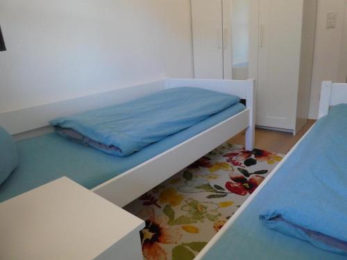 a bedroom with a bed with a blue blanket on it at Ferienwohnung Marktstüberl in Mittenwald