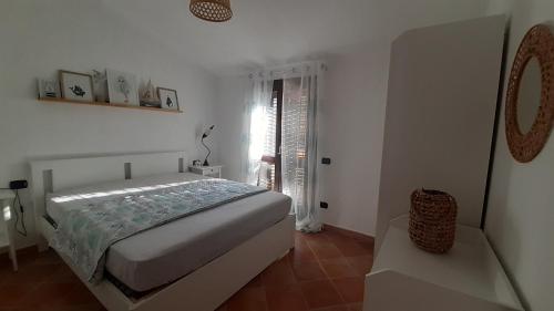 - une chambre blanche avec un lit et une fenêtre dans l'établissement Casa Alba, à SantʼAntìoco