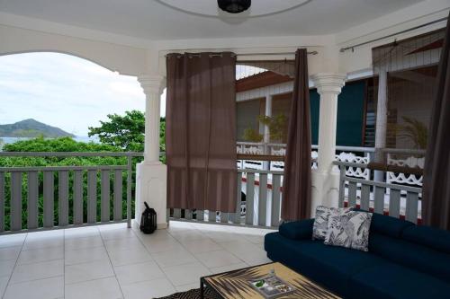 a living room with a blue couch on a porch at Belle demeure spacieuse in Mamoudzou