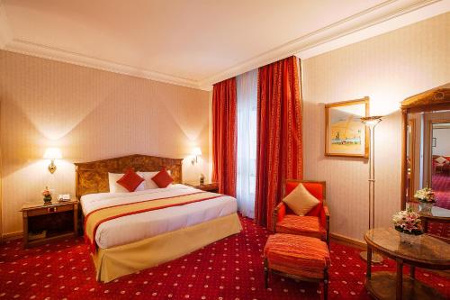 a hotel room with a bed and a chair at Capitol Hotel Jumeirah Dubai in Dubai