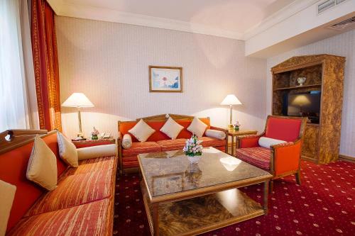 a living room with a couch and a table at Capitol Hotel Jumeirah Dubai in Dubai