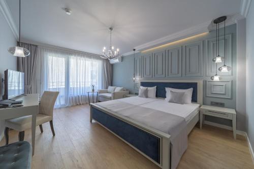 a bedroom with a large bed and a desk at Aquamarine - Beach & SPA Hotel- All inclusive in Kranevo