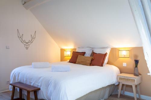 1 dormitorio con 1 cama blanca grande con almohadas en Cosy Chambord à 10 minutes du château, en Mont-près-Chambord