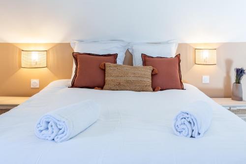 Una cama blanca con almohadas y toallas. en Cosy Chambord à 10 minutes du château, en Mont-près-Chambord