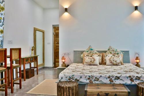 a bedroom with a bed and a table and a mirror at Shivohum Adventure Retreat in Sāmod