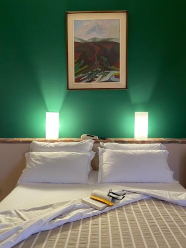 Una cama con dos lámparas encima. en Motel 70-Hotel, en San Nazzaro