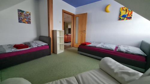 ein Zimmer mit 2 Betten und einem Sofa darin in der Unterkunft Apartmán Lidická in Vracov