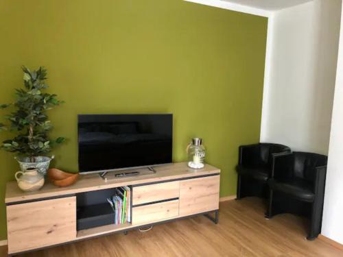 uma sala de estar com televisão num centro de entretenimento em madeira em Gemütliches Appartement mit eigener Terrasse em Lindau-Bodolz