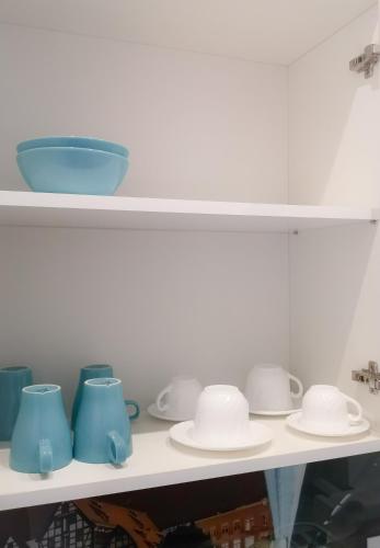 a shelf with blue and white bowls and plates at Softly Residence in Bydgoszcz