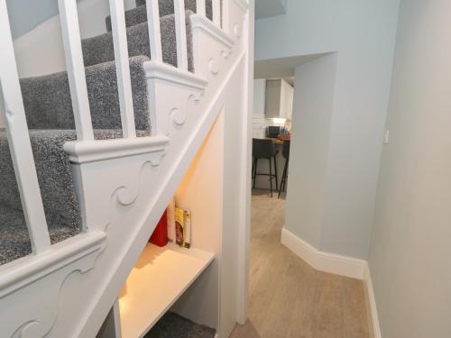 una escalera en una casa con barandillas blancas en Bryn Derfel en Porthmadog