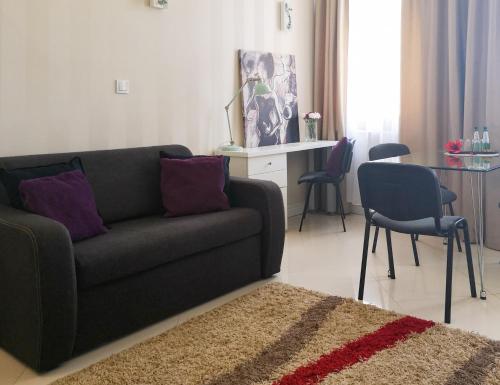 a living room with a couch and a table and chairs at Softly Residence in Bydgoszcz