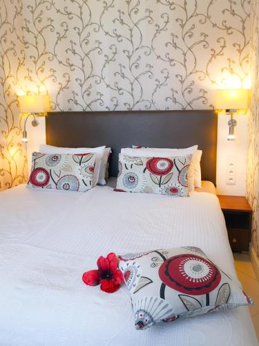 a bedroom with a white bed with red flowers on it at Softly Residence in Bydgoszcz