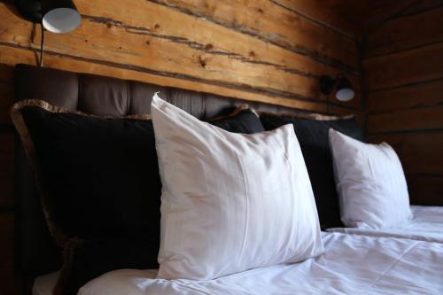 a bed with white pillows on top of it at Hemavans Wärdshus in Hemavan