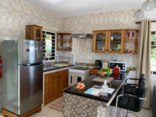 a kitchen with a stainless steel refrigerator at Crystal Apartments Seychelles SeaView Ground Floor in Glacis