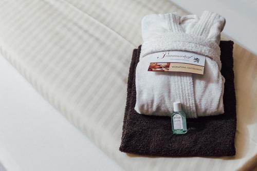 einen weißen Handschuh und eine Flasche Handlotion auf dem Bett in der Unterkunft Hotel Summerhof in Bad Griesbach