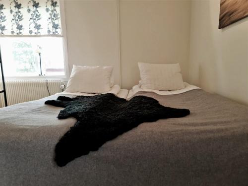 a black blanket laying on a bed in a bedroom at Hemavans Wärdshus in Hemavan