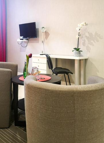 a living room with a chair and a desk with a computer at Softly Residence in Bydgoszcz