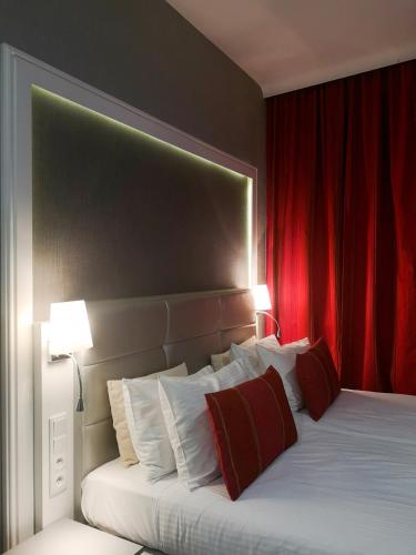a bedroom with a large bed with red curtains at Softly Residence in Bydgoszcz