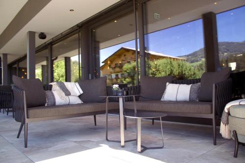 a room with two couches and a table and windows at THE MATTHEW - Copper Lodge in Wagrain