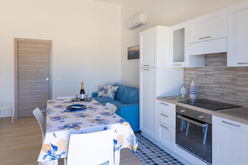 une cuisine et une salle à manger avec une table et un canapé bleu dans l'établissement L'Incanto di Mozia, à Marsala