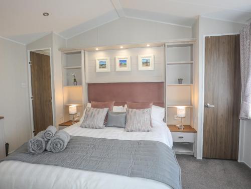 a bedroom with a large bed with pillows on it at 97 Crugan in Pwllheli