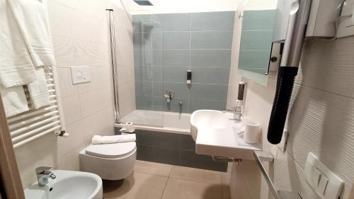a bathroom with a sink and a toilet and a tub at Gu Hotel in Guidonia