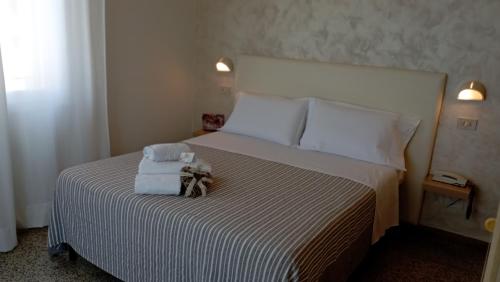 a bedroom with a bed with two towels on it at Hotel Raul in Riccione
