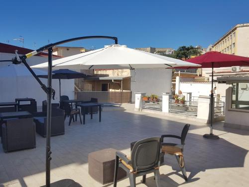 een patio met tafels, stoelen en parasols bij B&B Soriano44 in Napels